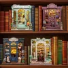 A collection of miniature bookshop models displayed on wooden shelves, surrounded by books. Náhled obrázku produktu