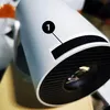 A close-up view of a white projector with a black textured lens and a numbered indicator. Náhled obrázku produktu