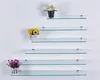 Several glass shelves are mounted on a white wall, with small potted plants on some of them. Produktbild-Vorschau