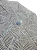 Close-up view of the top of a closed umbrella with a leaf pattern. Produktbild-Vorschau