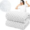 A woman wearing a sleep mask yawns, with a folded white blanket in the foreground and a close-up of the blanket's texture in the upper left corner. Náhled obrázku produktu