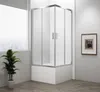 A modern bathroom corner with a glass shower enclosure, a plant, and framed artwork. Náhľad obrázku produktu