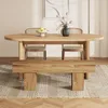 A wooden dining table and bench set in a room with a rug and artwork. Voir les images du produit
