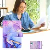 A woman is working at a desk with a laptop and papers, with a binder in the foreground. Voir les images du produit