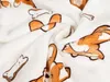 A close-up view of a soft, white blanket with a repeating pattern of cartoon corgi dogs and dog bones. Anteprima dell’immagine prodotto