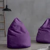 Two purple beanbag chairs are placed on a wooden floor in front of a gray concrete wall. A wooden ladder and a black pendant lamp are visible in the background. Produktbild-Vorschau