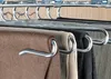 Close-up of multiple pairs of pants hanging on a multi-tiered hanger in a closet. Produktbild-Vorschau