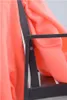 A close-up of a coral blanket draped over the armrest and back of a black metal park bench. Produktbild-Vorschau