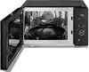 An open microwave oven with its interior visible, showing a turntable and the heating elements. Produktbild-Vorschau