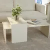 A modern living room setting with a beige sofa and a two-tiered coffee table. Voir les images du produit