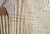 A close-up of a textured rug with a woven basket and fabric in the upper left corner. Produktbild-Vorschau