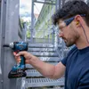 A man is using a Bosch cordless impact wrench on a metal structure next to a staircase. Voir les images du produit