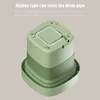 A top-down view of a green portable washing machine, highlighting its drain pipe storage feature. Náhled obrázku produktu