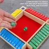 A hand is shown dropping dice onto a colorful board game. Náhled obrázku produktu