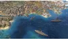A city built on a coastline with several battleships in the water. Produktbild-Vorschau