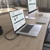 A laptop connected to an external monitor on a wooden desk, with a keyboard and mouse nearby. Voir les images du produit