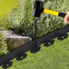 A person is using a mallet to hammer a stake into the ground to secure black lawn edging. Náhled obrázku produktu