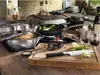 A kitchen scene with cooking utensils, food, and wine. Produktbild-Vorschau