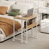 A small rolling desk with a laptop and a cup of coffee on it, placed next to a bed. Anteprima dell’immagine prodotto