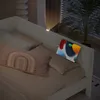 A bed with pillows and a tablet charging on the headboard. Náhled obrázku produktu