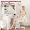 A woman is applying makeup while sitting on a chair in front of a vanity table. Náhled obrázku produktu