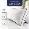 A close-up of a white pillow with a blue trim, set against a blurred background of bedding and greenery. Icons and text highlighting product features are present on the left side. Produktbild-Vorschau