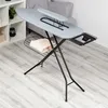 An ironing board is set up in a room with a shelf unit and a sofa in the background. Anteprima dell’immagine prodotto
