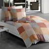 A bed with a patchwork duvet cover and pillows in a modern room. Produktbild-Vorschau