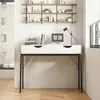 A modern desk with drawers and a black metal frame, set against a white wall with shelves above. Podgląd zdjęcia produktu