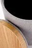 A close-up view of a round stool with a fabric exterior and a wooden lid. Anteprima dell’immagine prodotto