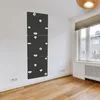 A climbing wall is mounted on a white wall in a room with wooden flooring and a window. Podgląd zdjęcia produktu