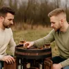 Two men playing a board game on a wooden barrel bar outdoors. Produktbild-Vorschau