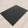 A black shower tray on a light wood-effect floor. Produktbild-Vorschau