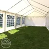 Interior view of a white party tent with green grass on the floor and windows on the side. Voir les images du produit