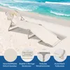 A beige beach lounger is set up on a sandy beach with the ocean in the background. Náhled obrázku produktu