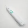 A white electric toothbrush is placed on a white surface. Produktbild-Vorschau