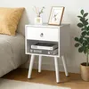 A white nightstand with a drawer and an open shelf, placed next to a bed. Decorative items are on top of the nightstand. Náhled obrázku produktu