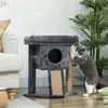 A cat is playing on a cat tree next to a sofa and a plant. Produktbild-Vorschau