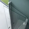A close-up view of a modern shower door, partially open, showing its glass panels and metal frame. Produktbild-Vorschau