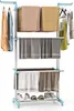 A three-tier drying rack with clothes and towels on it, and shoes on the bottom shelf. Voir les images du produit