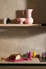 A kitchen counter with a loaf of bread on a cutting board, and various kitchenware items on a shelf and counter. Produktbild-Vorschau