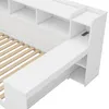 A close-up view of a white bed frame with built-in shelving and a desk extension. Produktbild-Vorschau