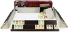 A rummy set with tiles and racks is displayed on a white surface, with its packaging in the background. Náhľad obrázku produktu