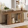 A wooden console table with arched cabinet doors and open shelving, placed behind a sofa in a living room setting. A lamp and decorative items are on top of the table. Podgląd zdjęcia produktu