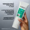 A hand holding a Redken hair product with text overlays describing its benefits. Náhled obrázku produktu