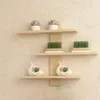 Three wooden shelves mounted on a tiled wall, decorated with plants and decorative items. Produktbild-Vorschau