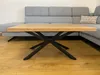 A wooden coffee table with black metal legs is placed in front of a grey sectional sofa. Anteprima dell’immagine prodotto