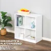 A white cube shelf unit with four compartments, decorated with books, a basket of fruit, and a small deer figurine. A plant is visible to the left. Text overlays promote the product. Produktbild-Vorschau