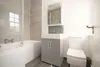 A bathroom with a bathtub, vanity, and toilet. Produktbild-Vorschau