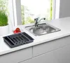 A kitchen counter with a sink, faucet, and a cutlery organizer. Produktbild-Vorschau